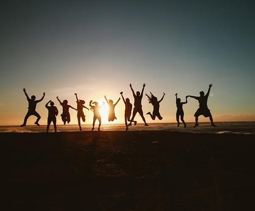 Группа людей на закате прыгает